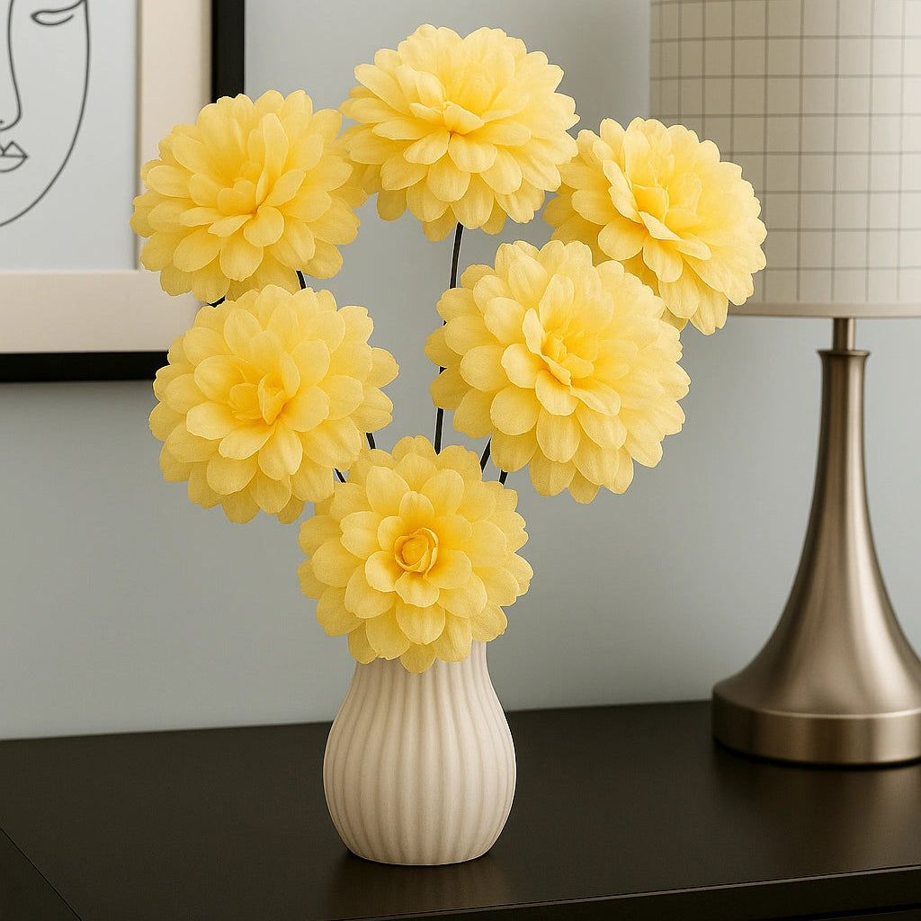 Yellow flowers in a white vase on a dark surface with a lamp and framed picture in the background.