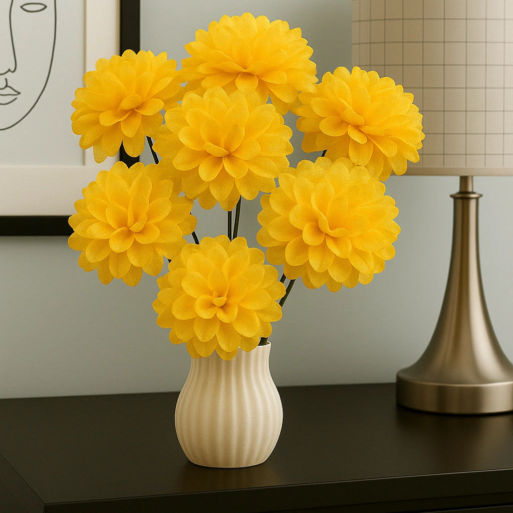 Yellow flowers in a white vase on a dark surface with a lamp and framed picture in the background.