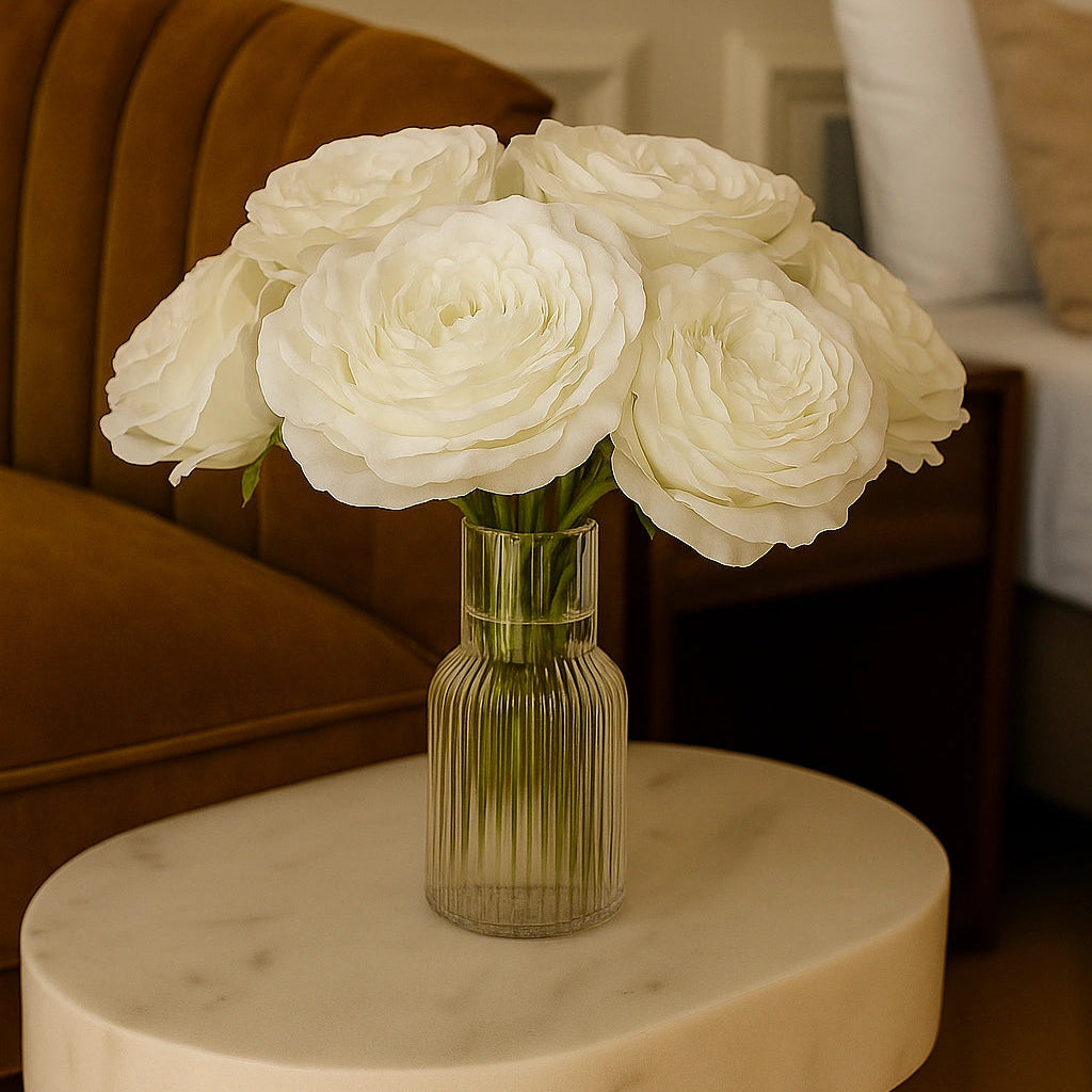 Bouquet of white roses in a glass vase on a marble table with a blurred background