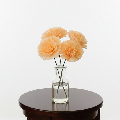 Vase with peach-colored flowers on a wooden table against a white background