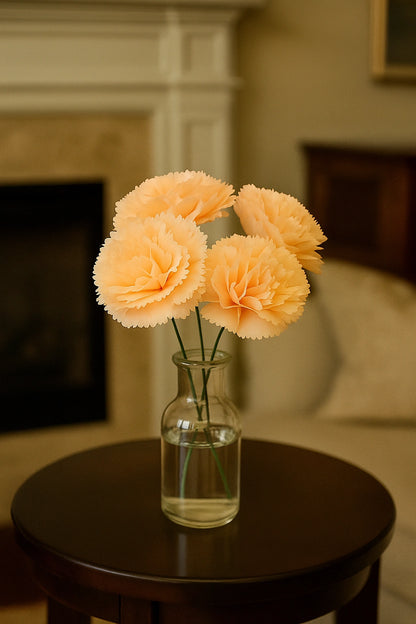 Vase with peach-colored flowers on a wooden table in a room with a fireplace and couch.