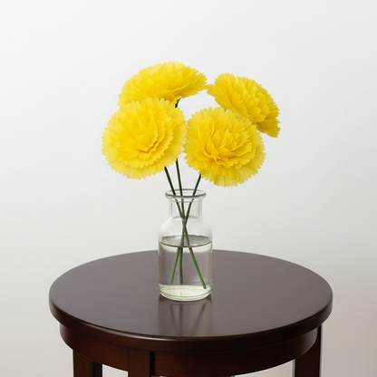 Yellow flowers in a glass vase on a dark wooden table against a white background