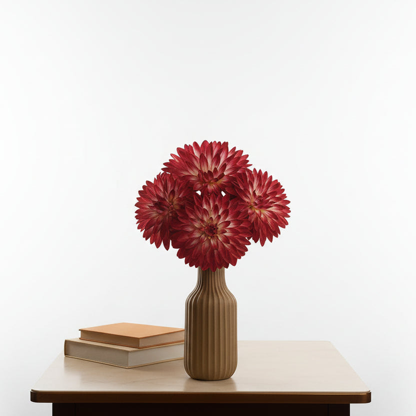 Red flowers in a vase on a table with a blurred background