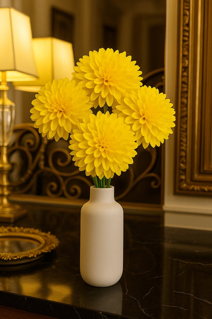 Yellow flowers in a white vase on a dark surface with a decorative background