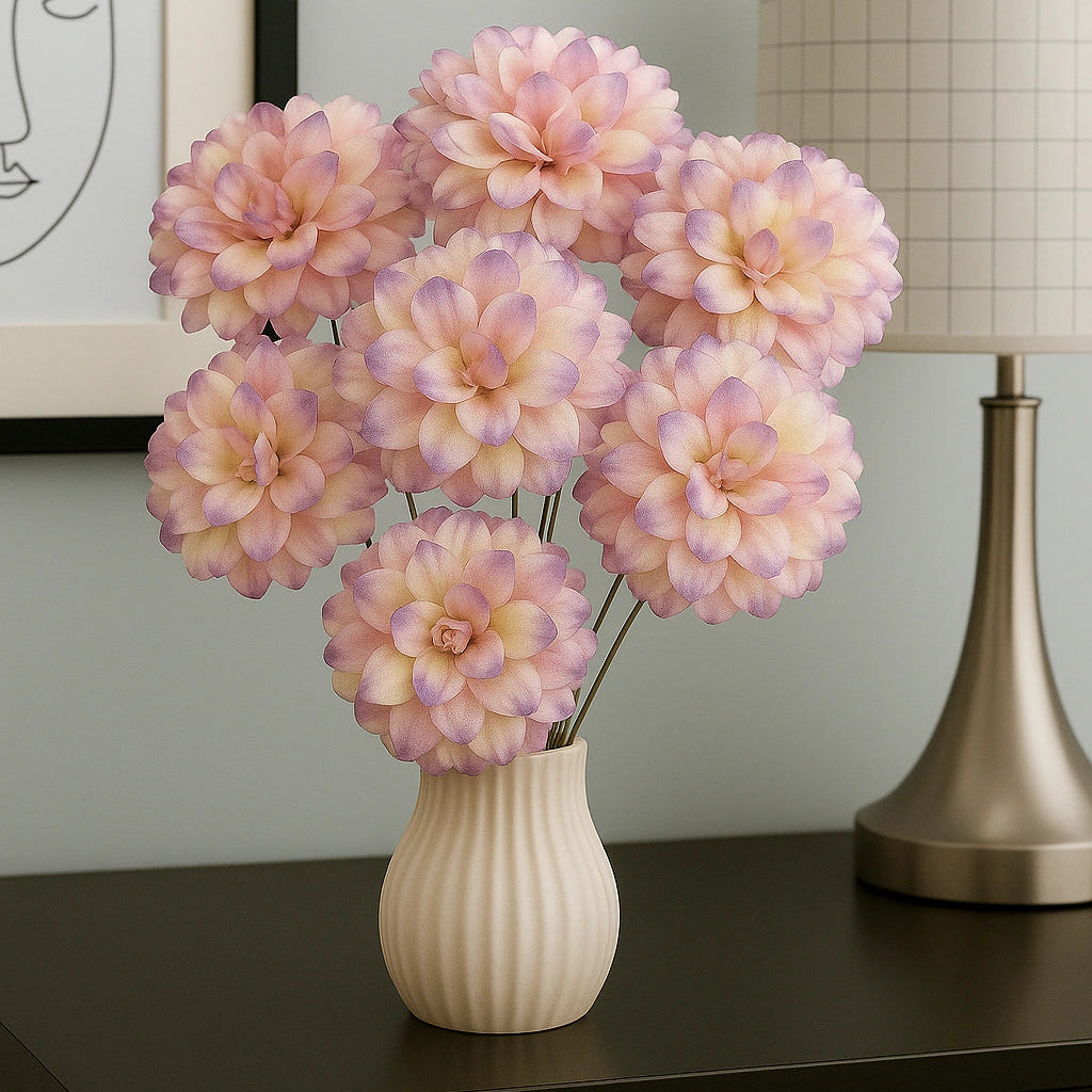 Vase with pink and purple flowers on a dark surface with a lamp and framed picture in the background.