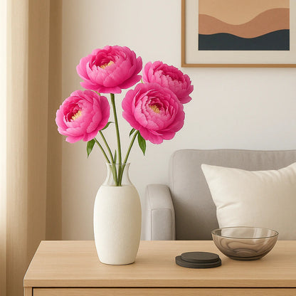 Pink flowers in a white vase on a wooden side table with a sofa and framed artwork in the background.