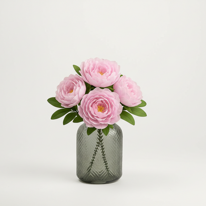 Pink flowers in a textured gray vase on a light gray background