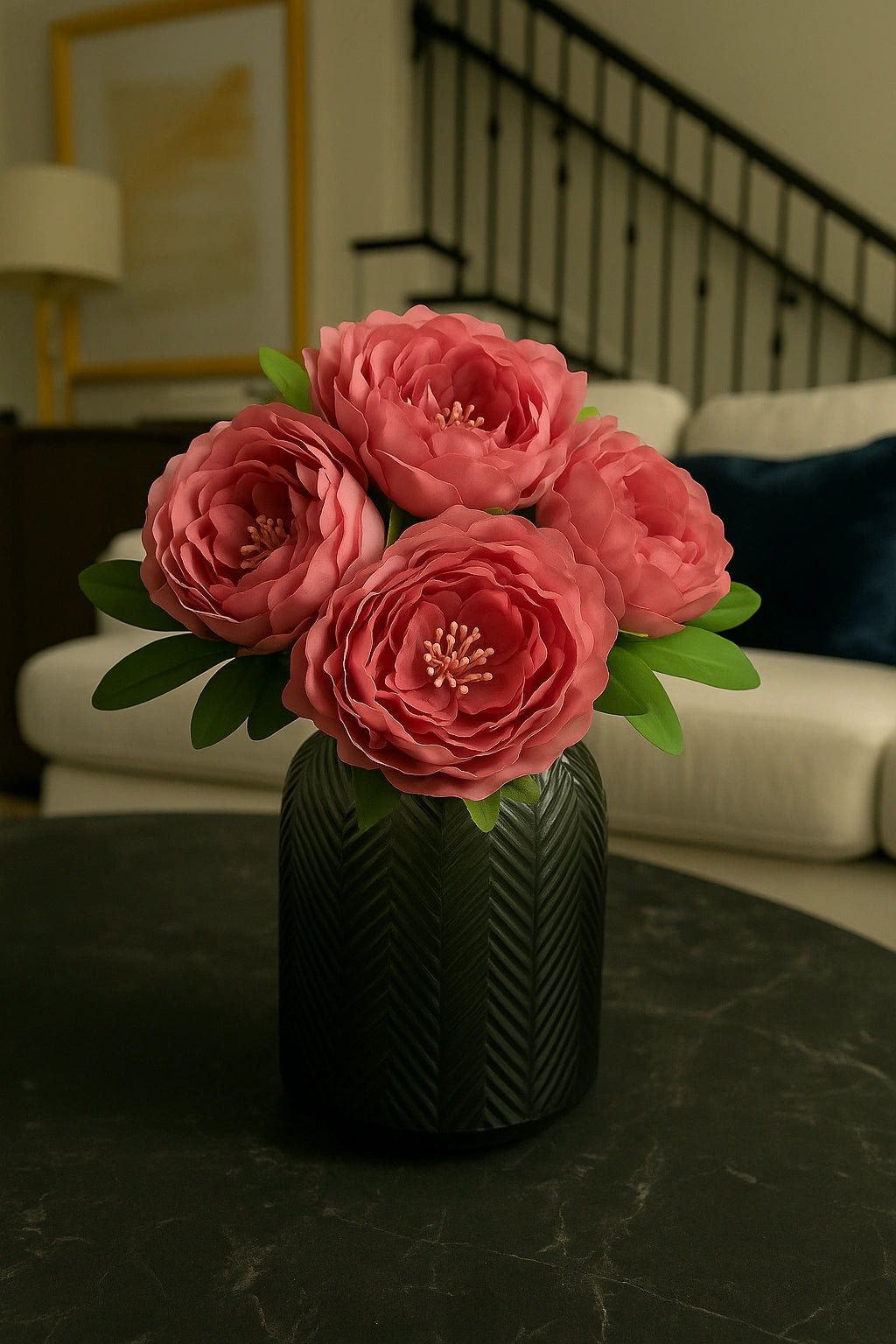 Pink flowers in a black vase on a dark surface with a blurred indoor setting