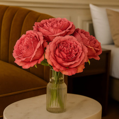 Bouquet of pink roses in a glass vase on a marble table with a blurred background
