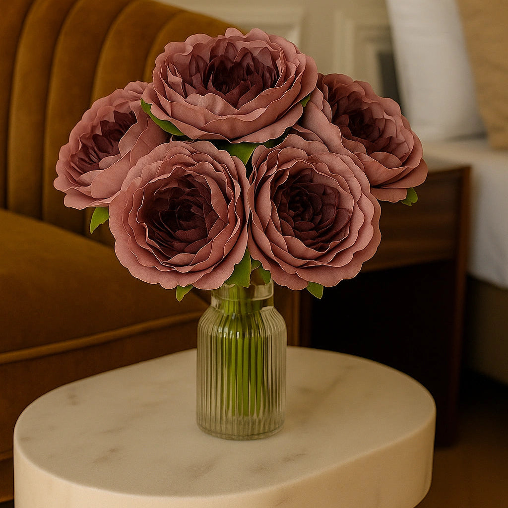 Bouquet of pink roses in a clear vase on a marble table with a blurred background