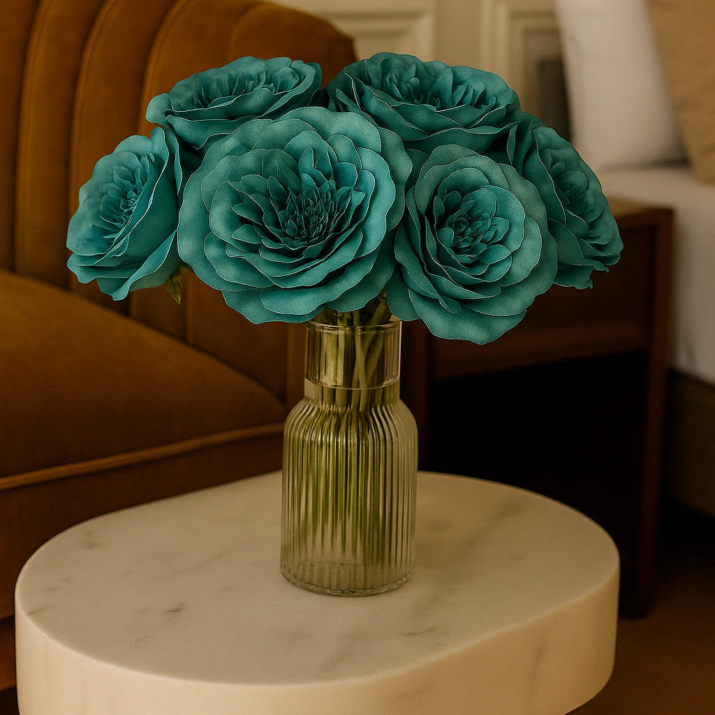 Teal flowers in a vase on a marble table with a blurred indoor setting