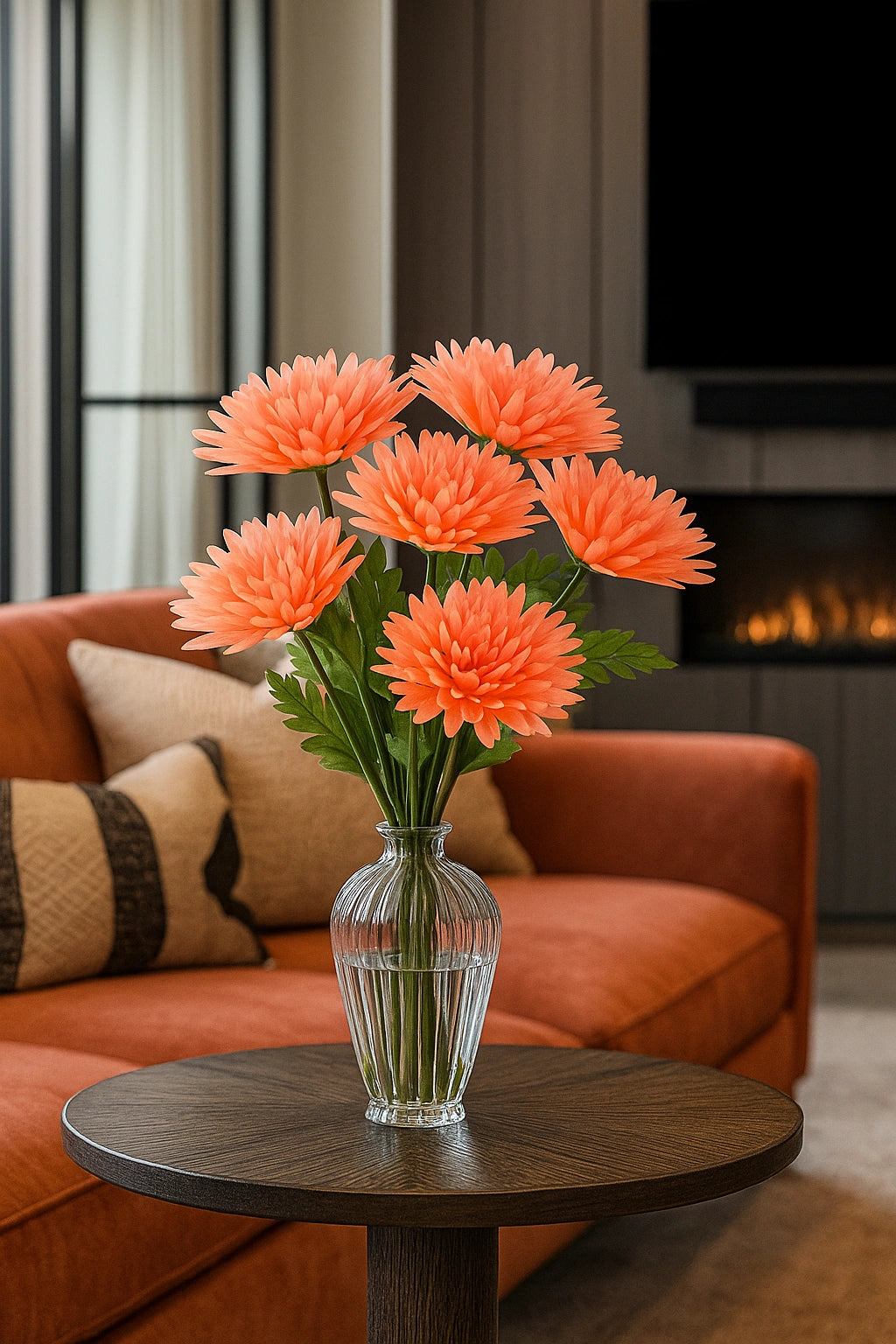 Clear vase with orange flowers on a wooden table in a living room.