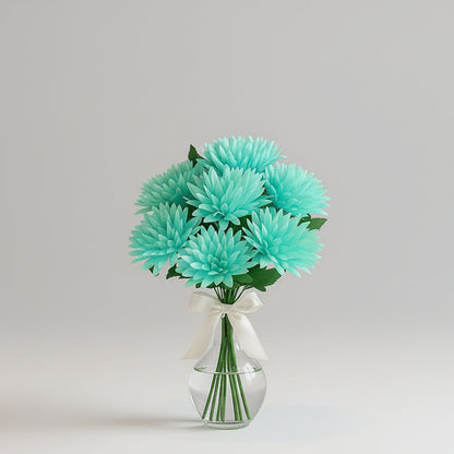 Turquoise flowers in a clear vase on a marble table with a neutral-colored sofa and window in the background.