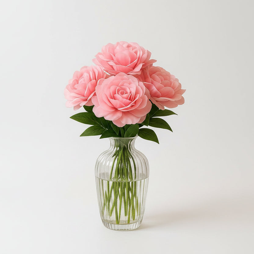 Pink roses in a clear vase on a marble table in a living room.