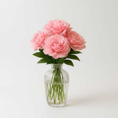 Pink roses in a clear vase on a marble table in a living room.